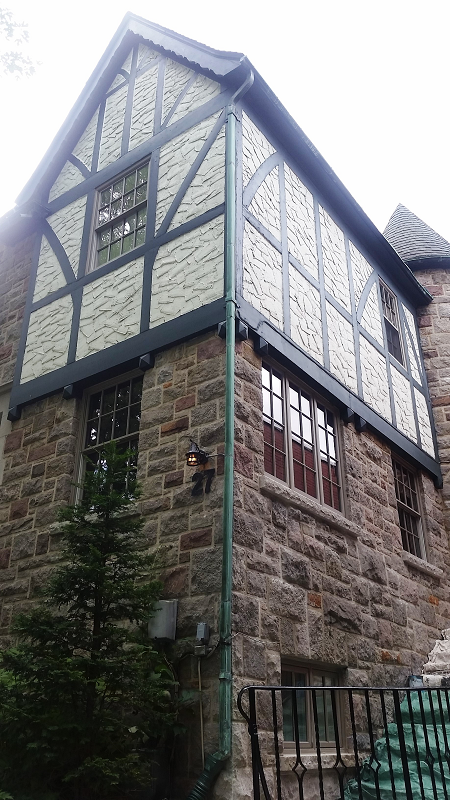 Un grand bâtiment en brique avec une gouttière verte sur le côté.
