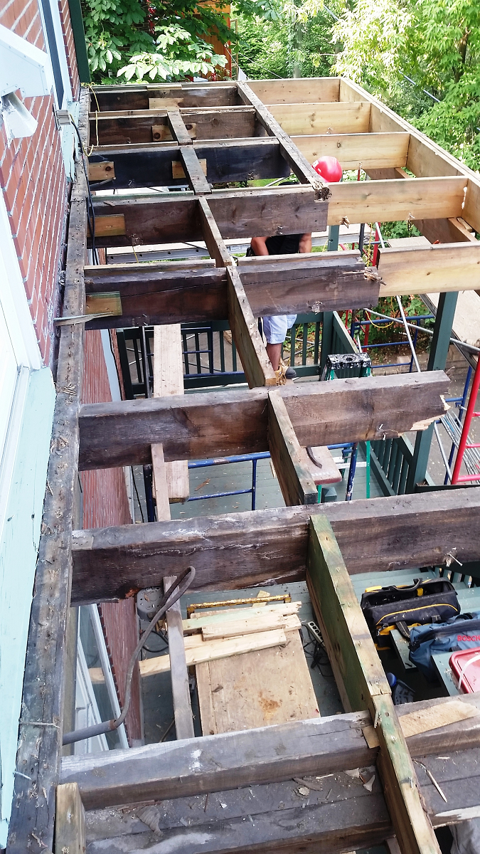 Une terrasse en bois est en cours de construction sur le côté d'un bâtiment.