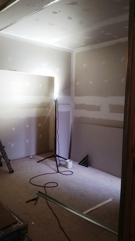 Une pièce avec beaucoup de cloisons sèches et une lumière au sol.