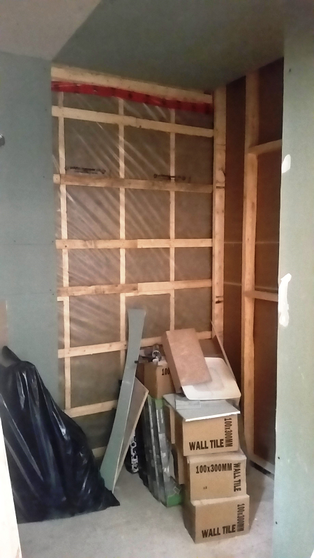 Une pièce avec des cartons empilés les uns sur les autres et un mur en bois.