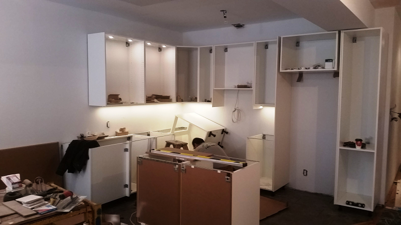 Une cuisine en cours de rénovation avec des armoires blanches
