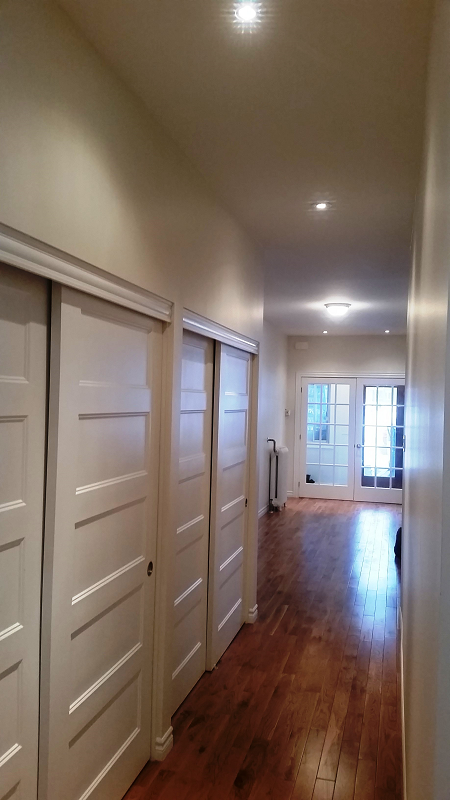 Un couloir avec portes coulissantes menant à un salon