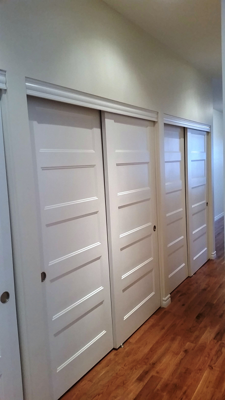 Un couloir avec portes coulissantes et parquet