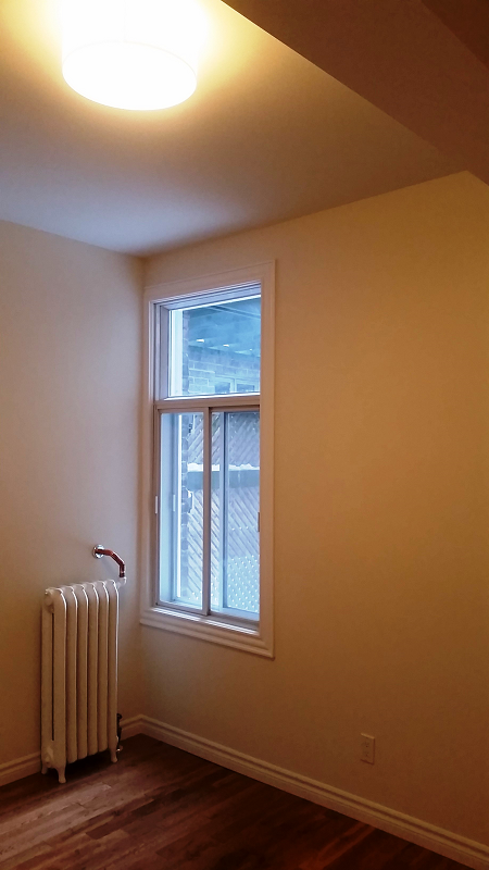 Une pièce vide avec un radiateur et une fenêtre.