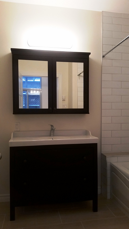 Une salle de bain avec lavabo , miroir et baignoire.