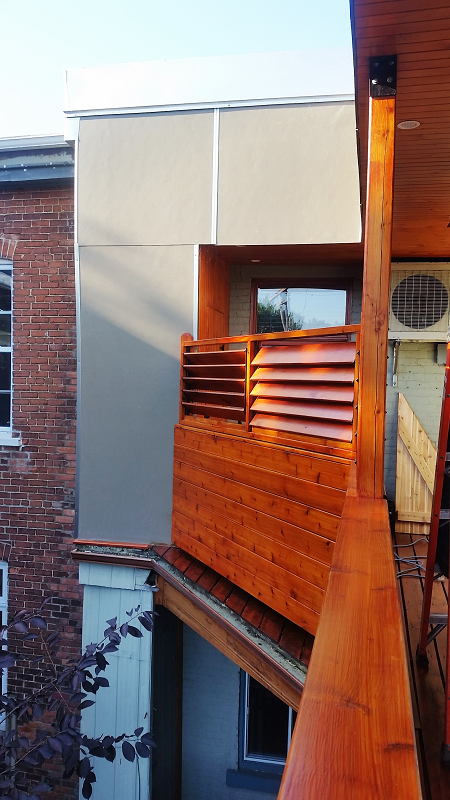 Un balcon sur le côté d'un immeuble avec une balustrade en bois.