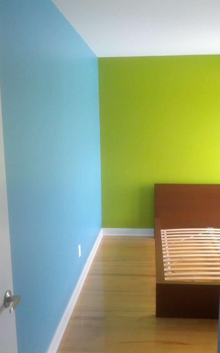 Une chambre avec des murs bleus et verts et un lit