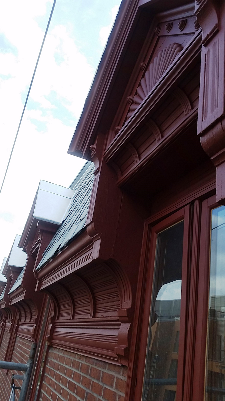 Un gros plan d'un bâtiment en brique avec une fenêtre et un toit.