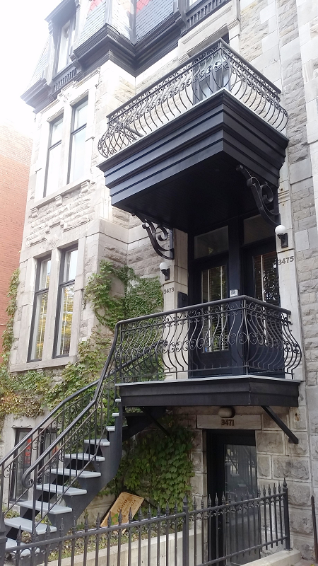 Un immeuble avec un balcon et des escaliers qui y mènent