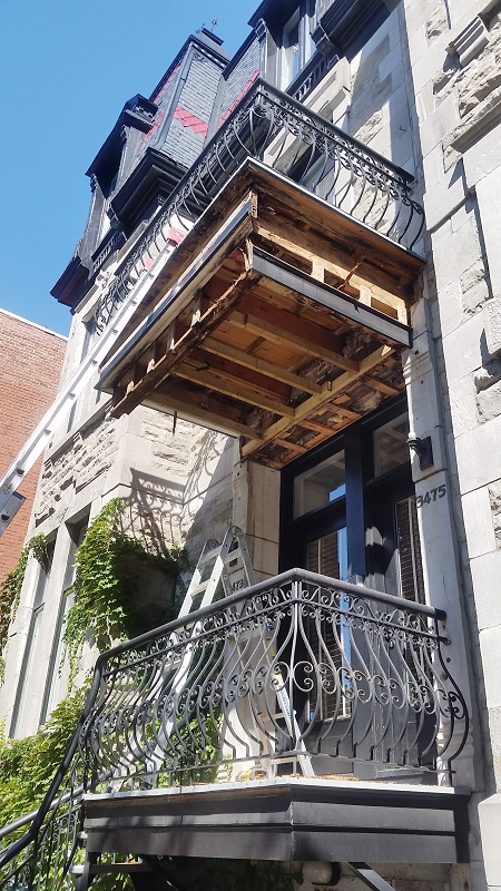 Un balcon est en cours de construction sur le côté d'un immeuble.