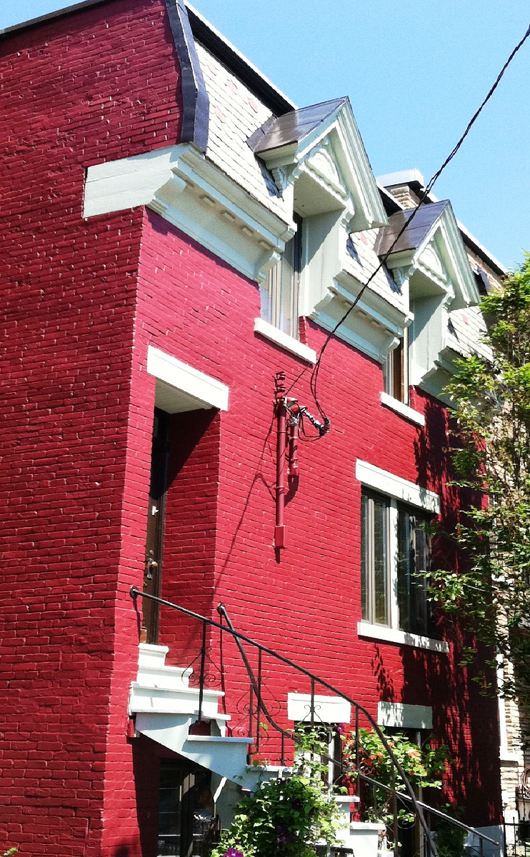 Un bâtiment en brique rouge avec des boiseries et des escaliers blancs