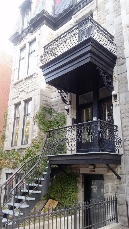 Un immeuble avec un balcon et des escaliers qui y mènent