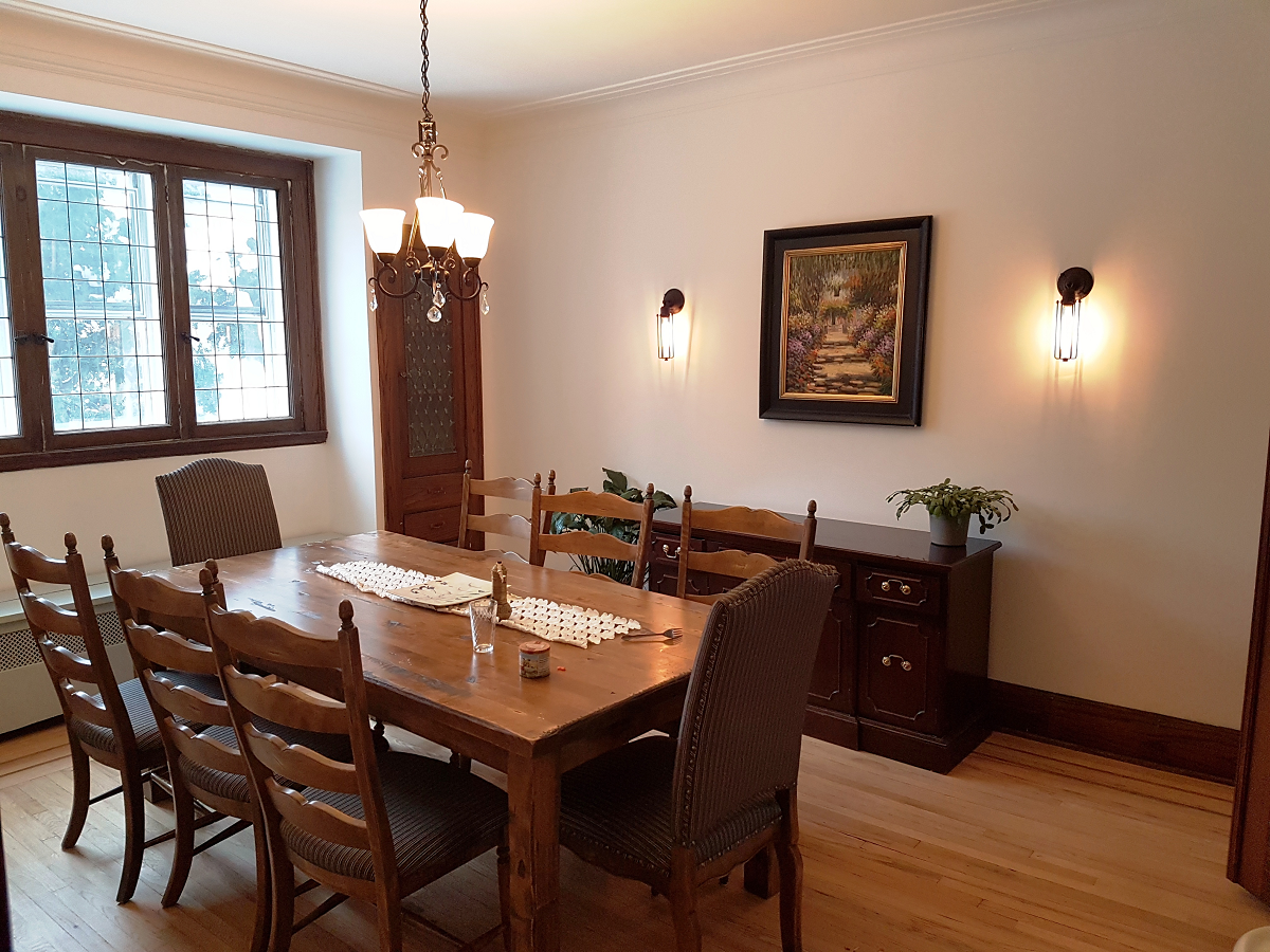 Une salle à manger avec une longue table et des chaises en bois