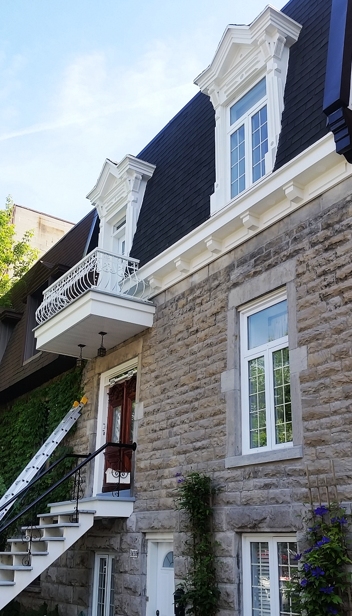 Une grande maison en pierre avec des escaliers menant à la porte d'entrée.