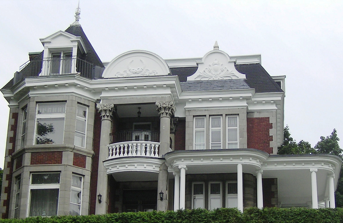 Une grande maison en brique avec balcon et colonnes