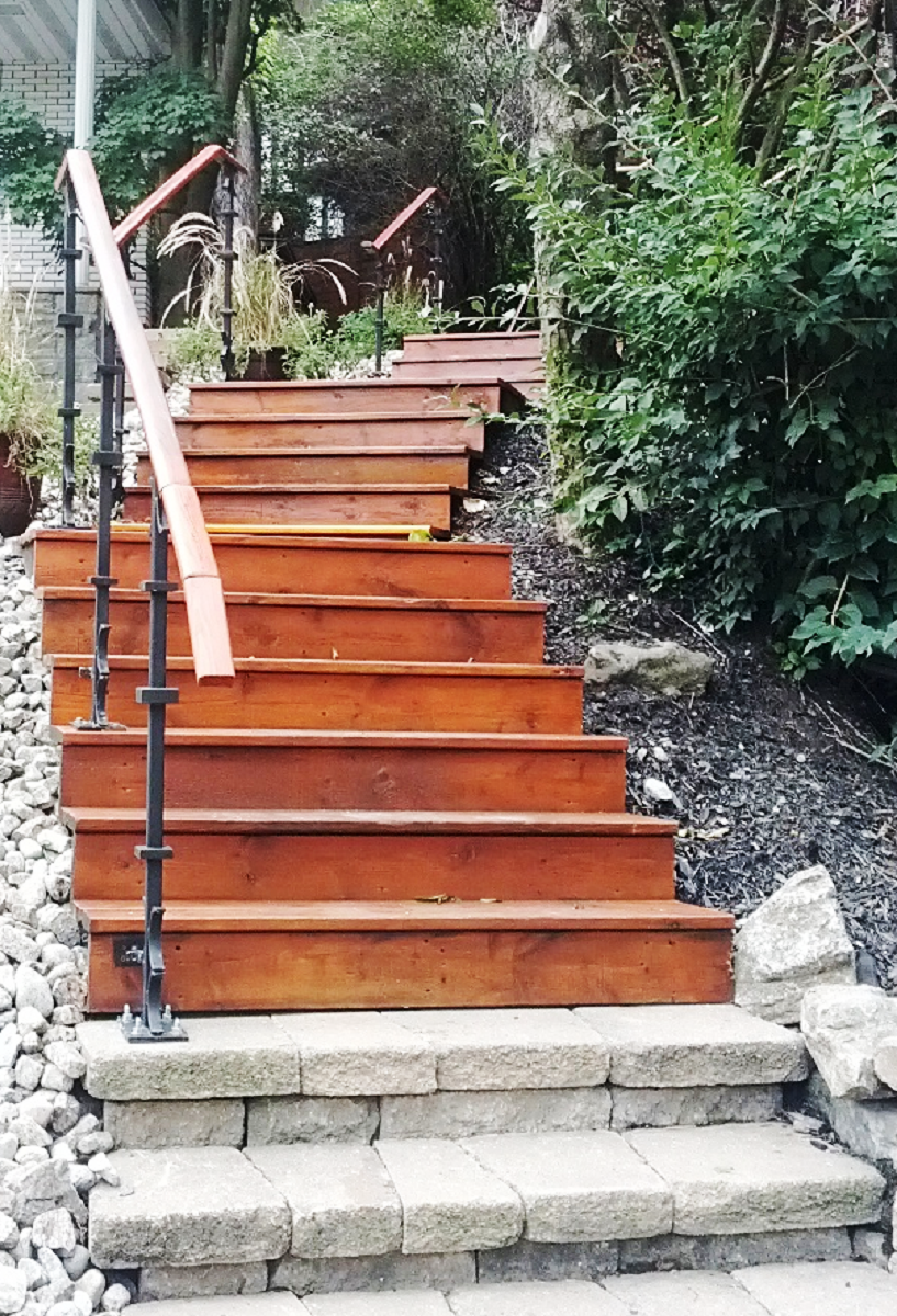 Un escalier en bois avec une rampe en métal