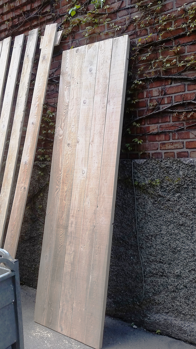 Un gros morceau de bois est posé devant un mur de briques.
