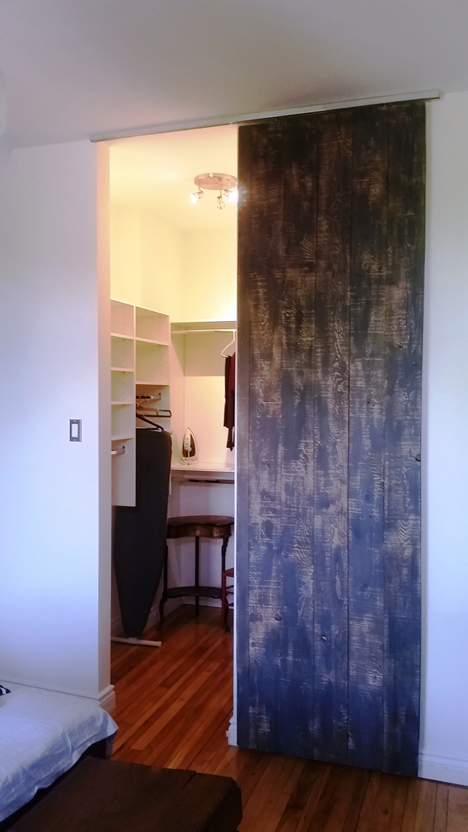 Une chambre avec une porte coulissante menant à un dressing.