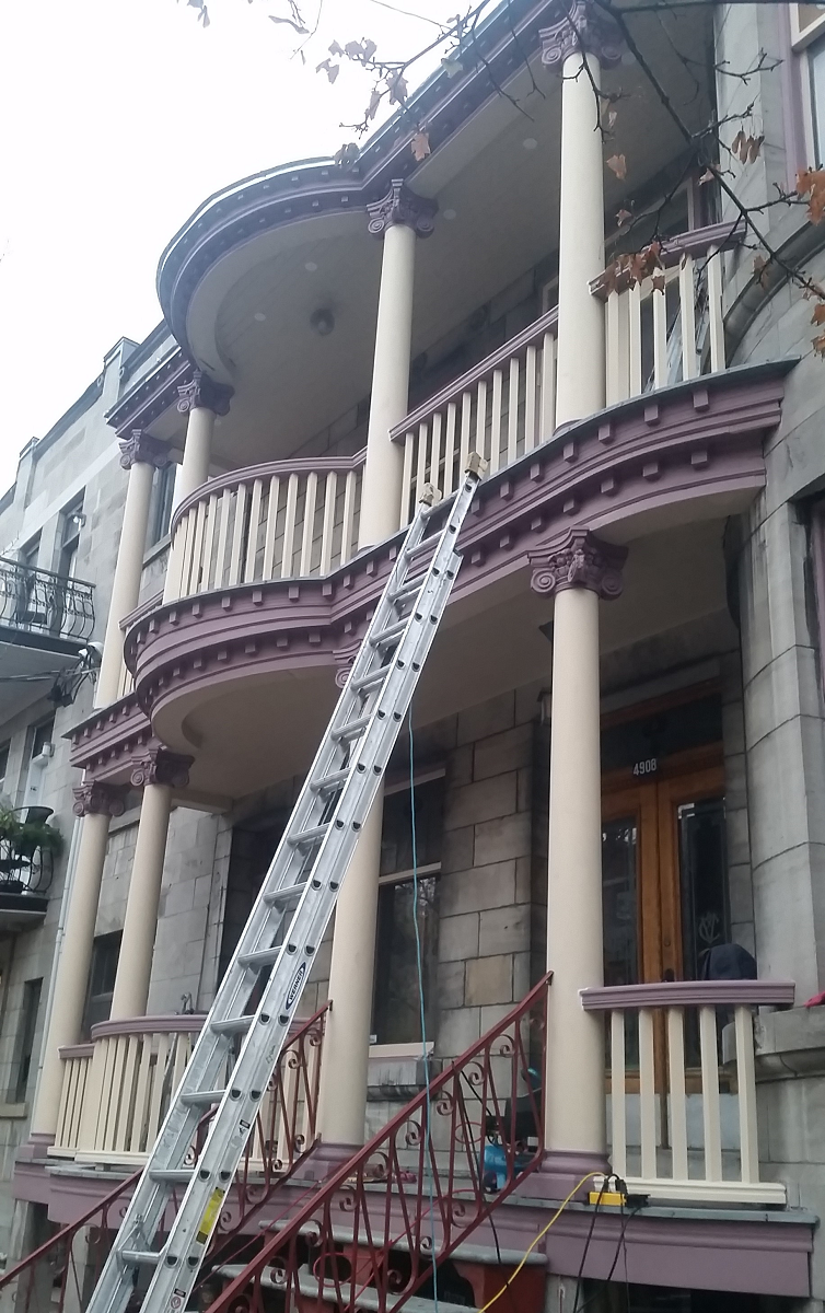 Une échelle est posée sur le côté d'un bâtiment.