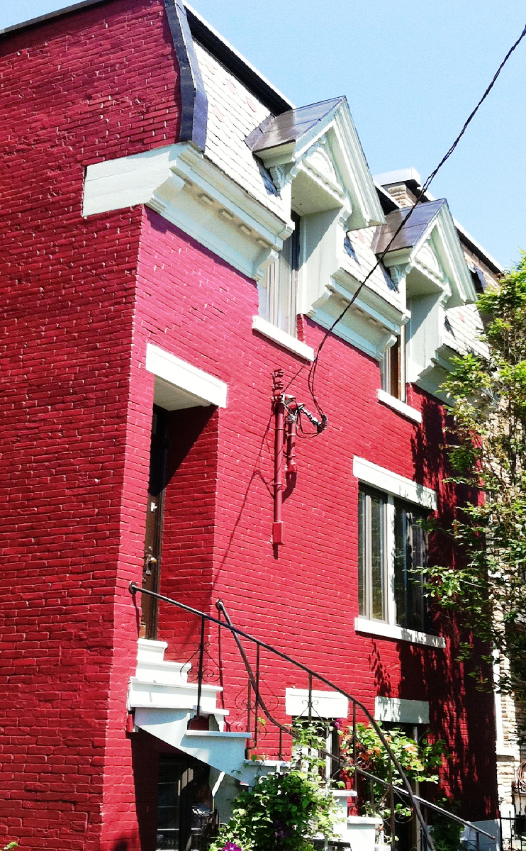 Un bâtiment en brique rouge avec des boiseries et des escaliers blancs