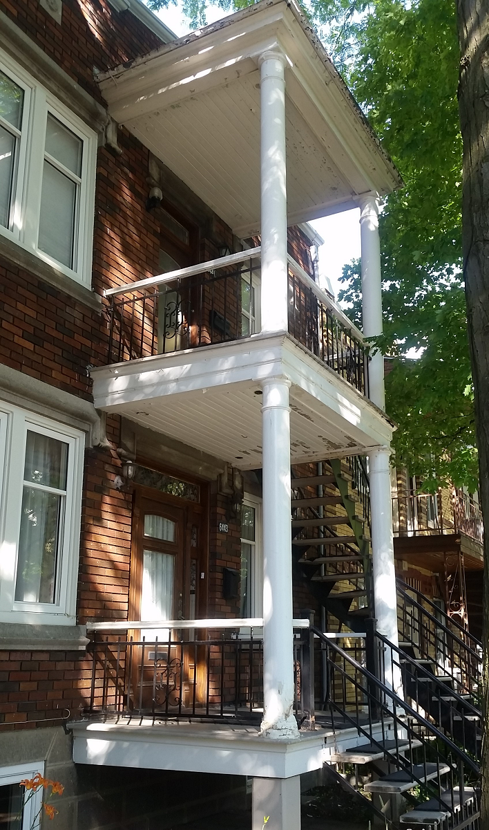 Un bâtiment en brique avec un balcon et des escaliers