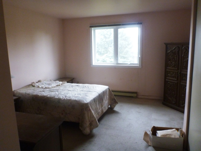 Une chambre vide avec un lit et une fenêtre