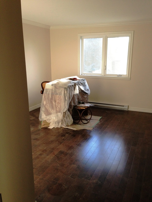 Une pièce vide avec du parquet et une fenêtre.