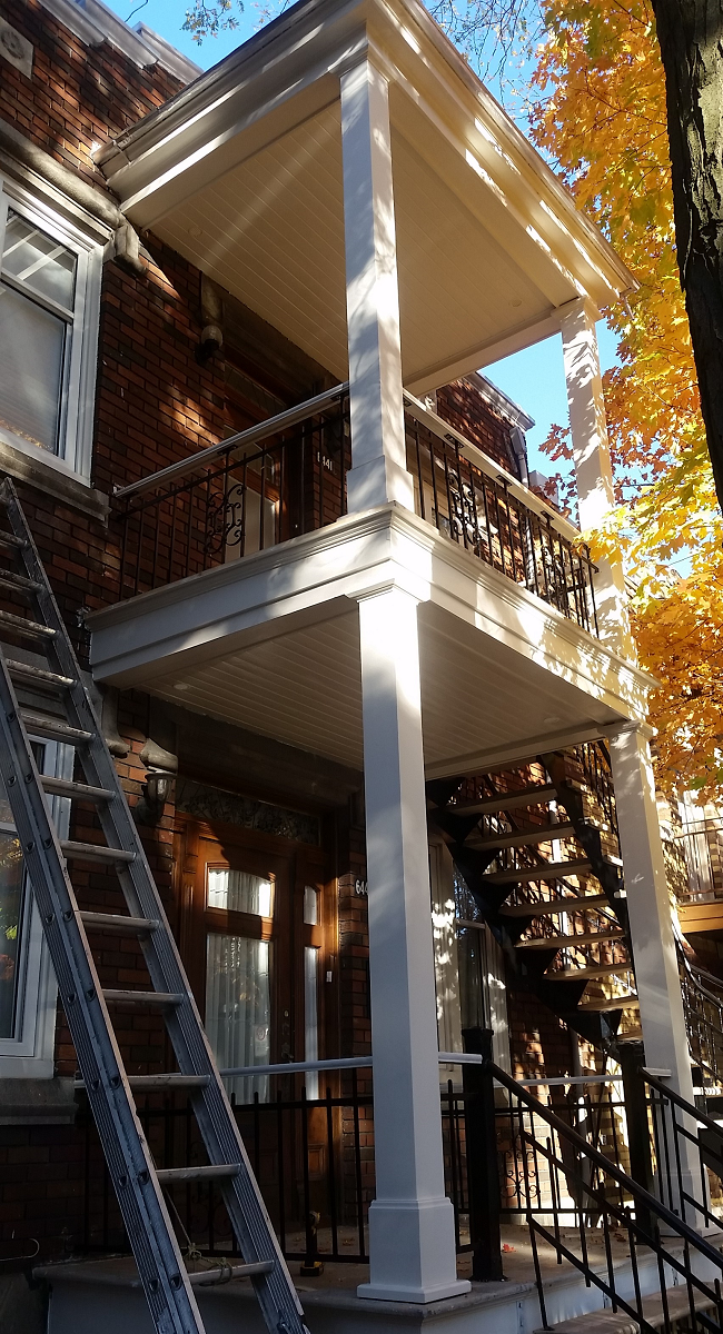 Une maison avec un balcon et des escaliers sur le côté