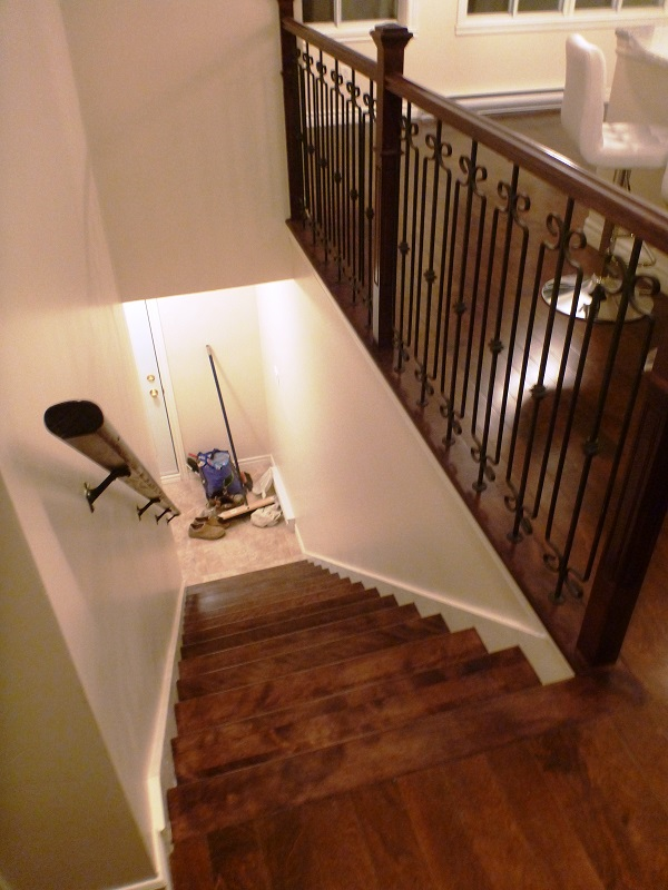 Un escalier en bois avec une rampe en fer forgé
