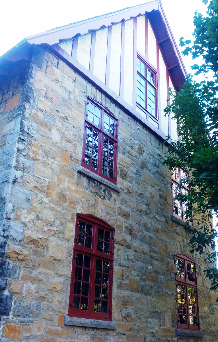 Un bâtiment en brique avec des fenêtres rouges et un toit blanc
