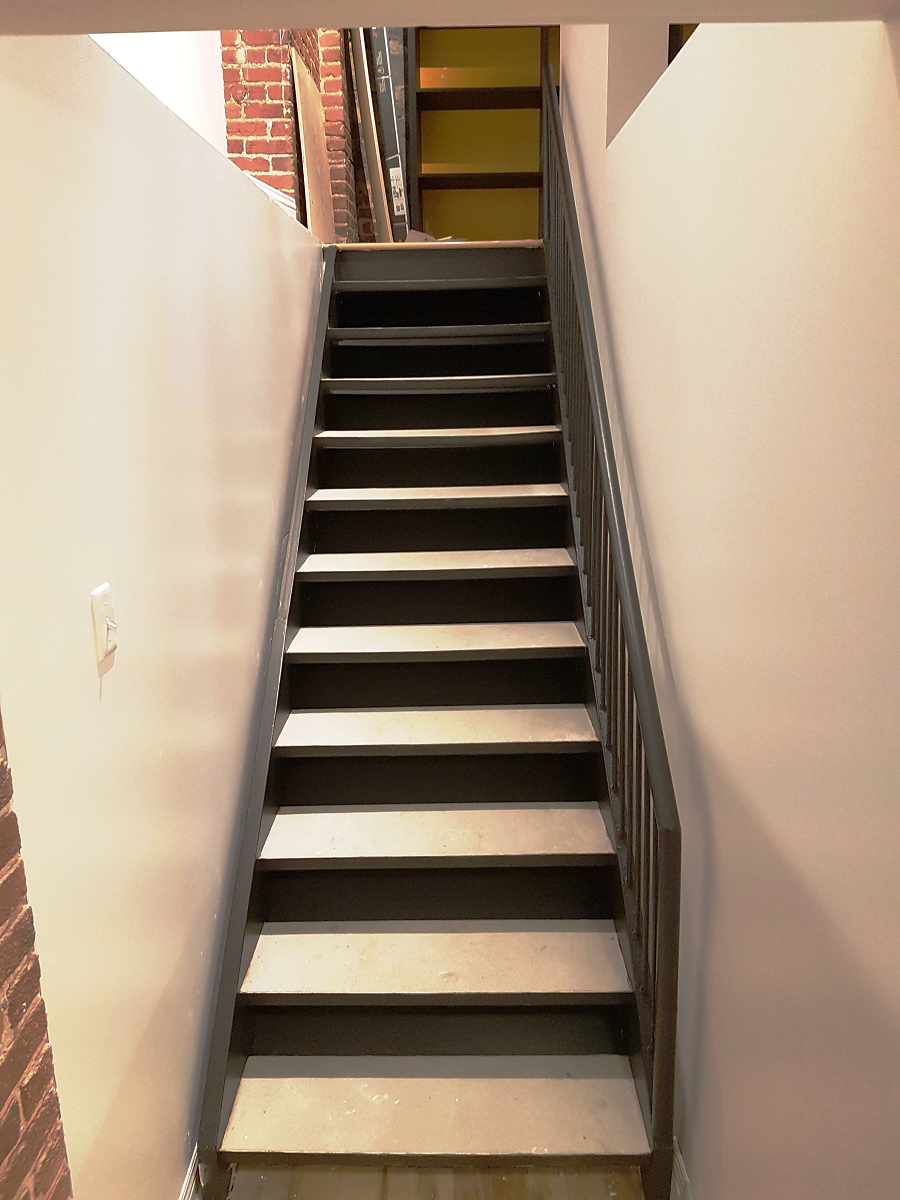 Un escalier menant à un mur de briques