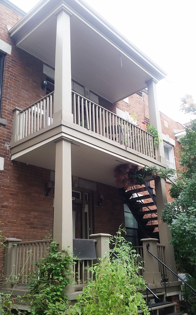 Une maison en brique avec balcon et escalier