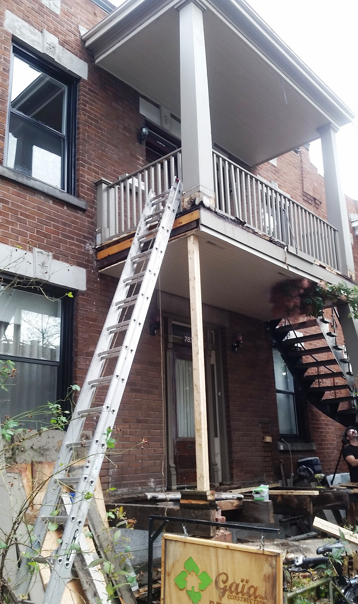 Une échelle se trouve sur le côté d'un bâtiment en brique.