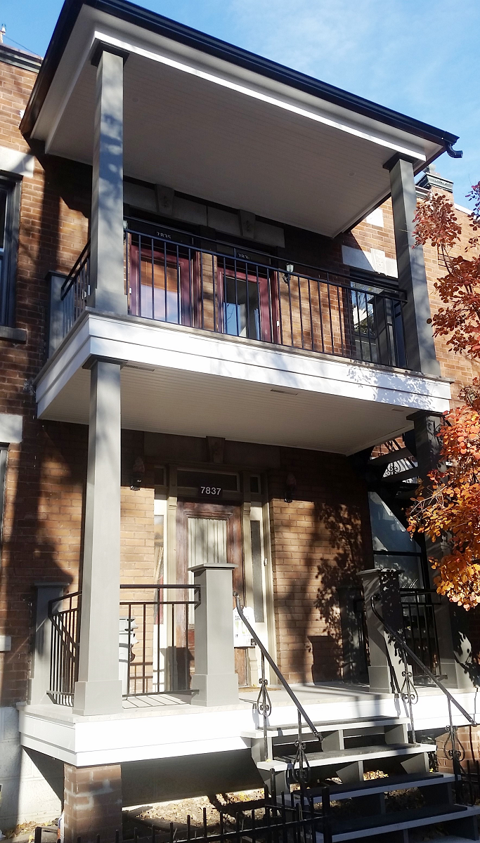 Un grand bâtiment en brique avec balcon et escalier.