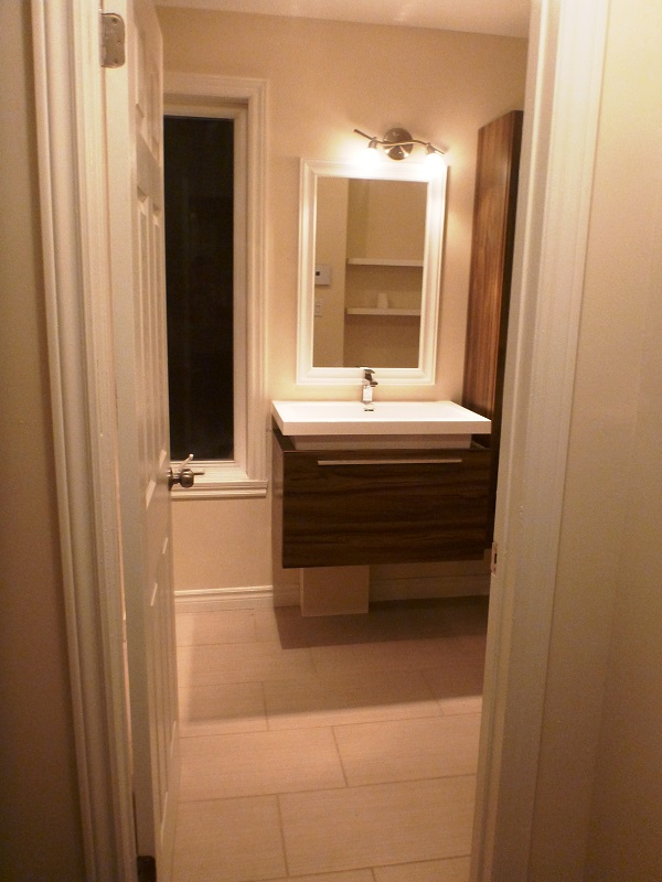 Une salle de bain avec lavabo , miroir et fenêtre.