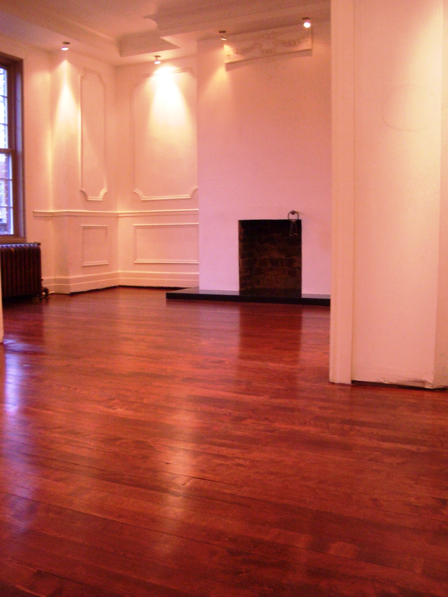 Une pièce vide avec parquet et cheminée
