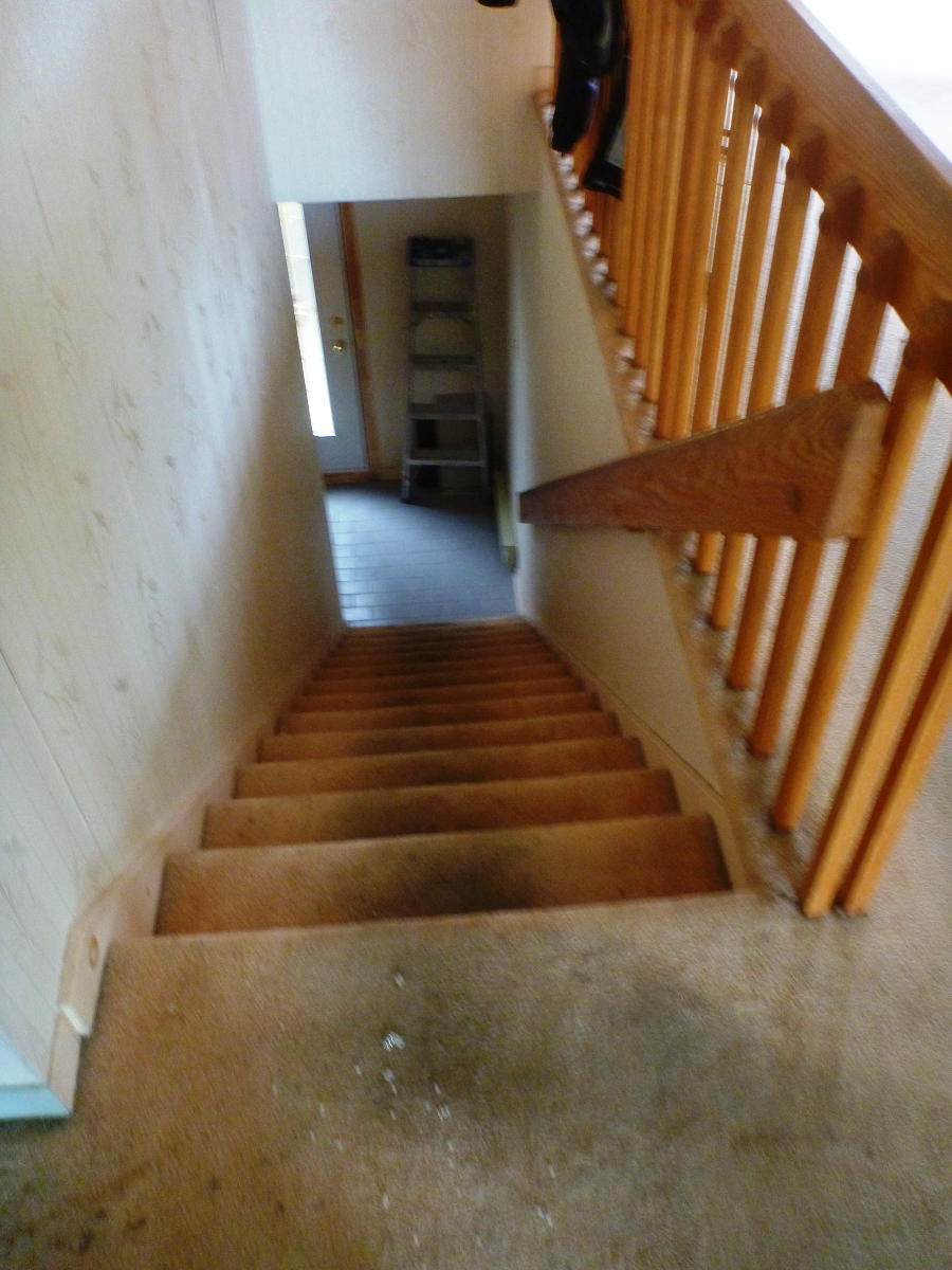 Un escalier avec une rampe en bois montant au deuxième étage