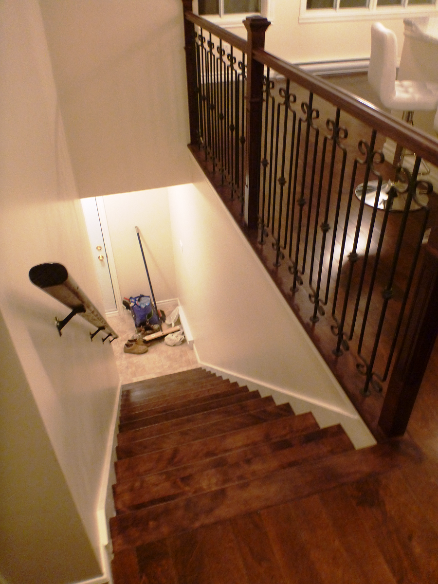 Un escalier en bois avec une rampe en fer forgé