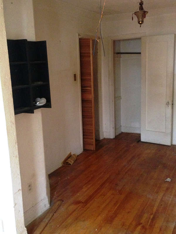 Une pièce vide avec parquet et murs blancs