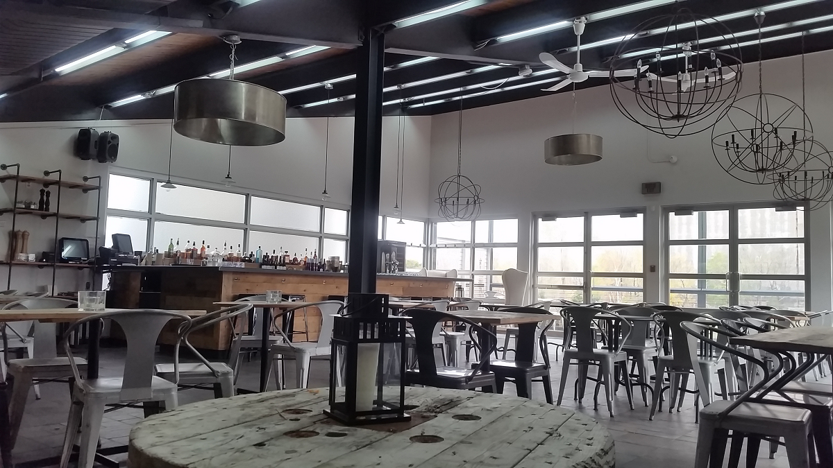 Un restaurant avec tables et chaises et une grande fenêtre.