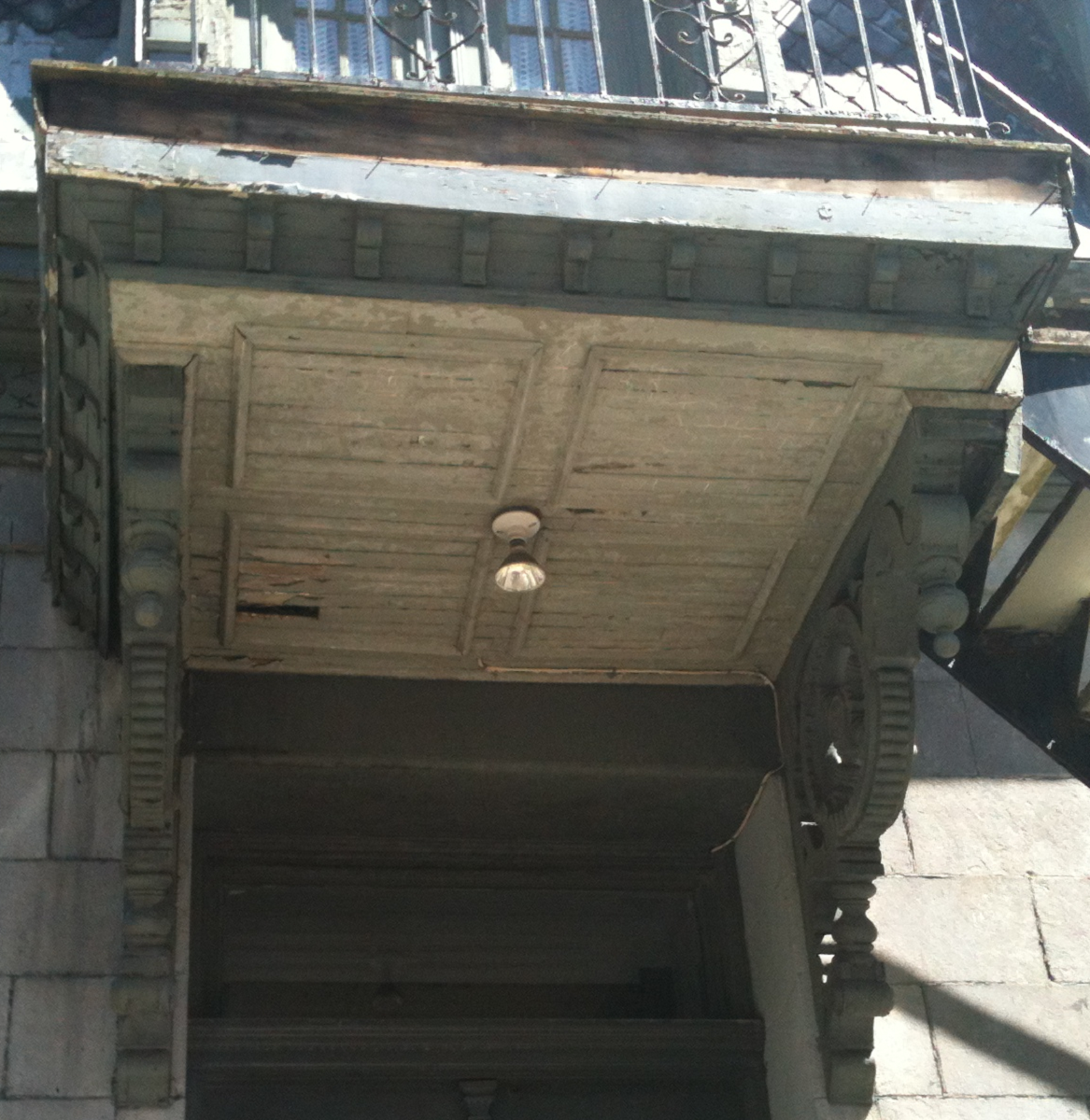 Une porte en bois avec une balustrade en métal au-dessus