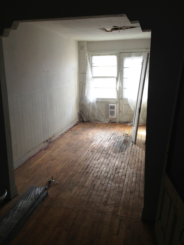 Une pièce vide avec parquet et murs blancs