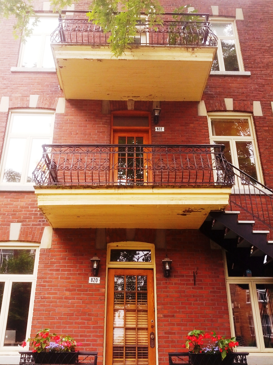Un bâtiment en brique avec un balcon et des escaliers