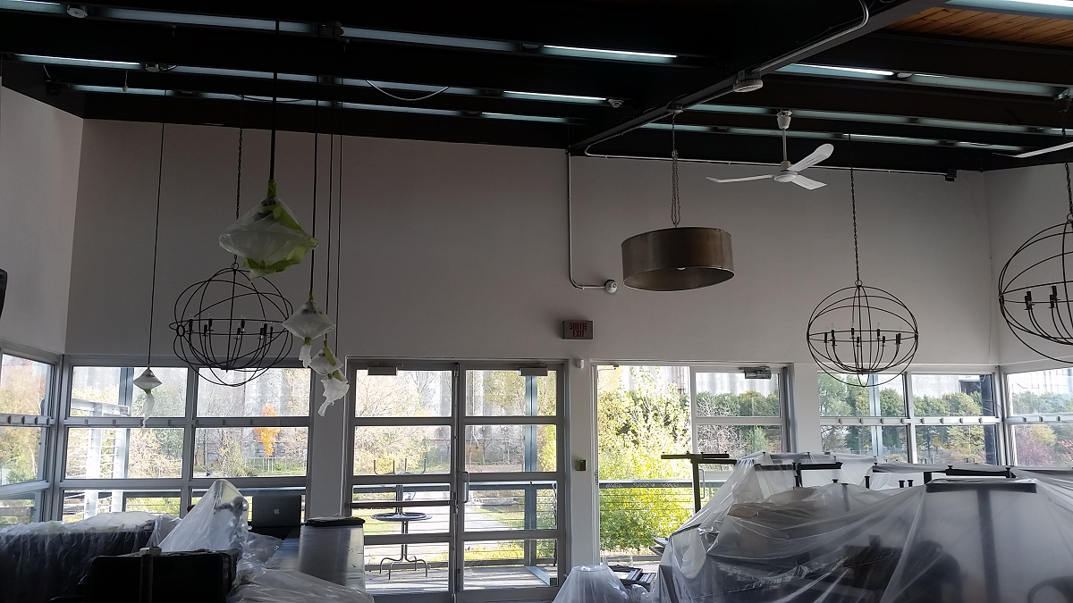 Une pièce avec beaucoup de fenêtres et un ventilateur de plafond