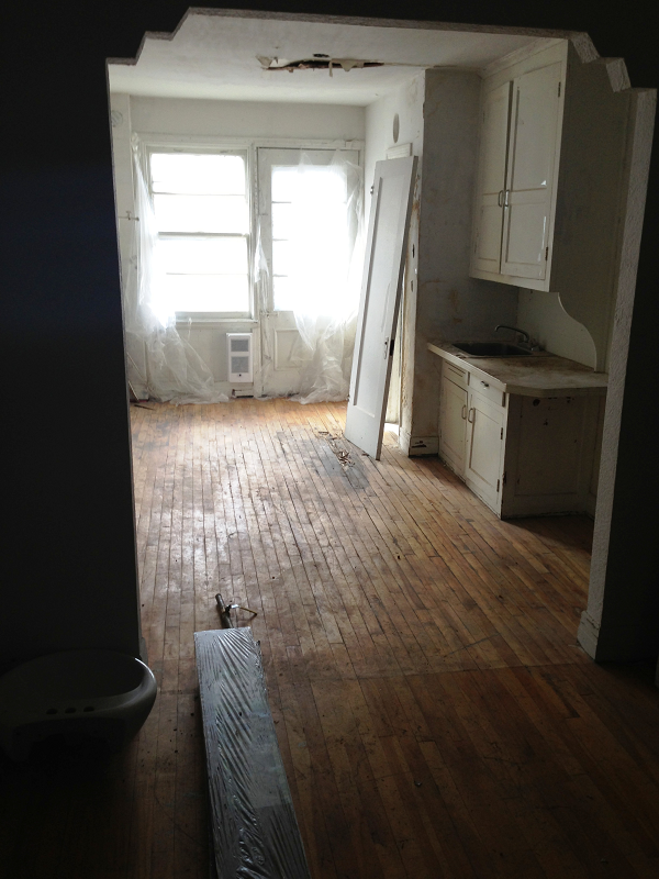 Une pièce vide avec parquet et armoires blanches