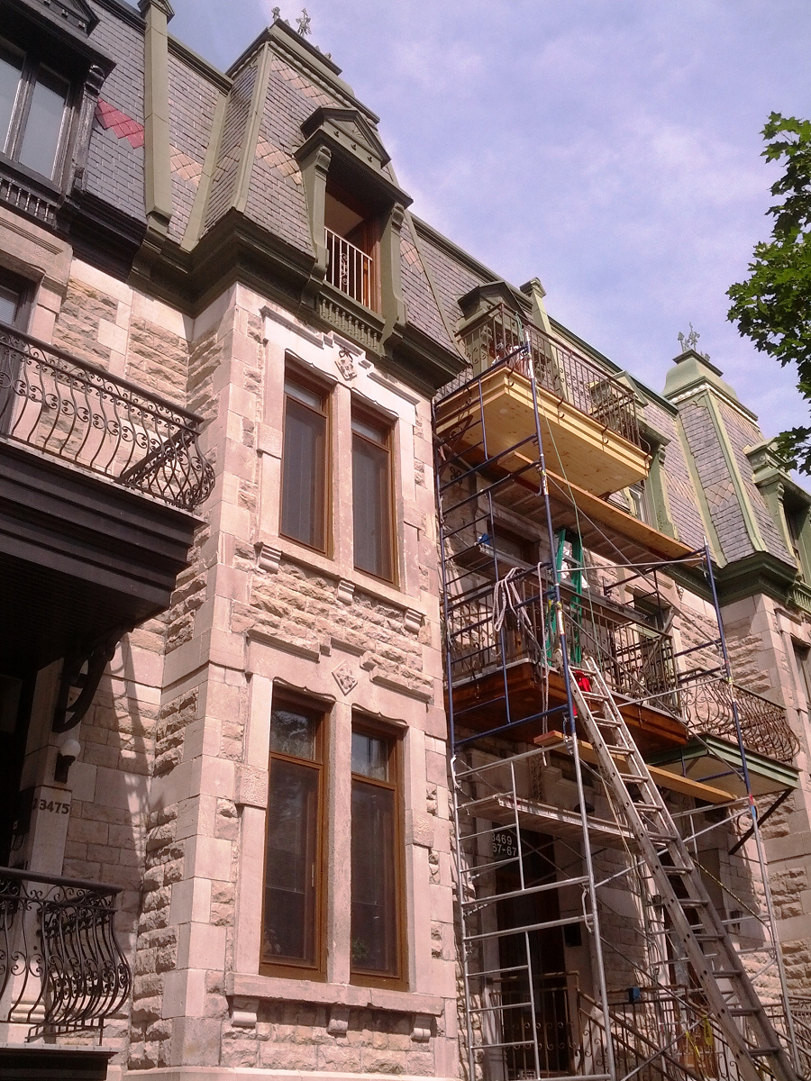 Un grand bâtiment en pierre avec des échafaudages sur le côté