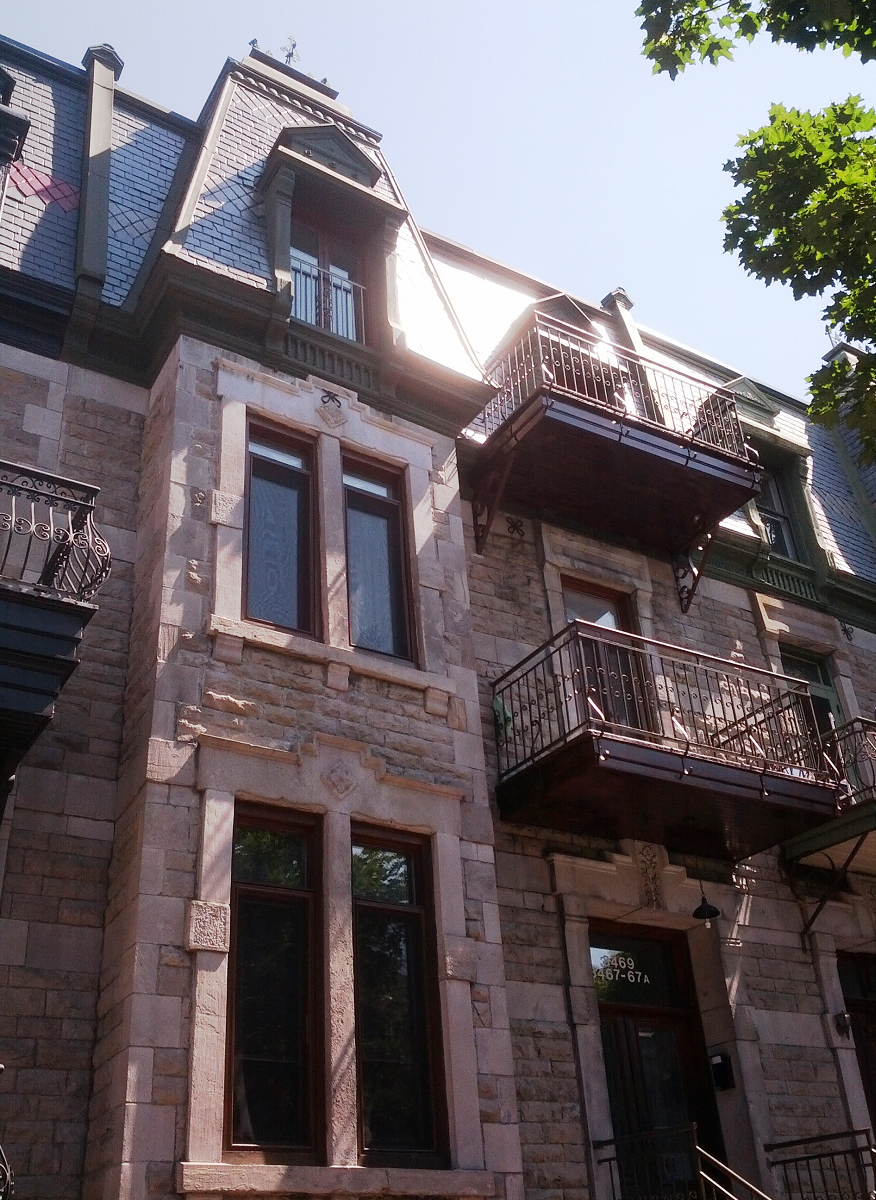 Un grand bâtiment en brique avec balcon et escaliers