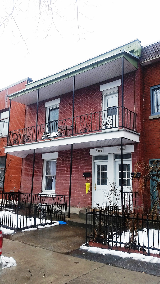 Un bâtiment en brique avec un balcon et une bouche d'incendie devant