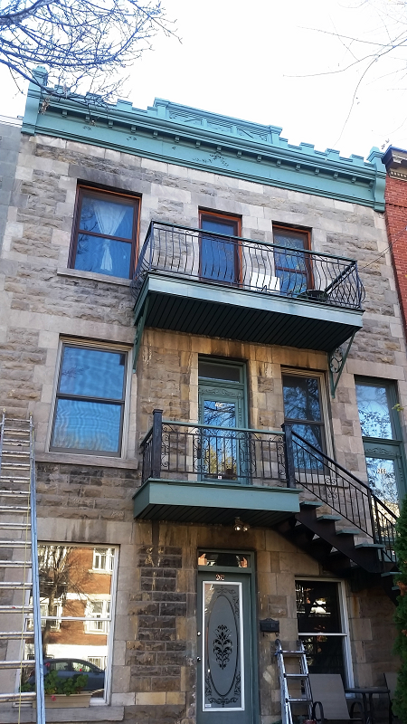 Un grand bâtiment en pierre avec balcon et escalier.