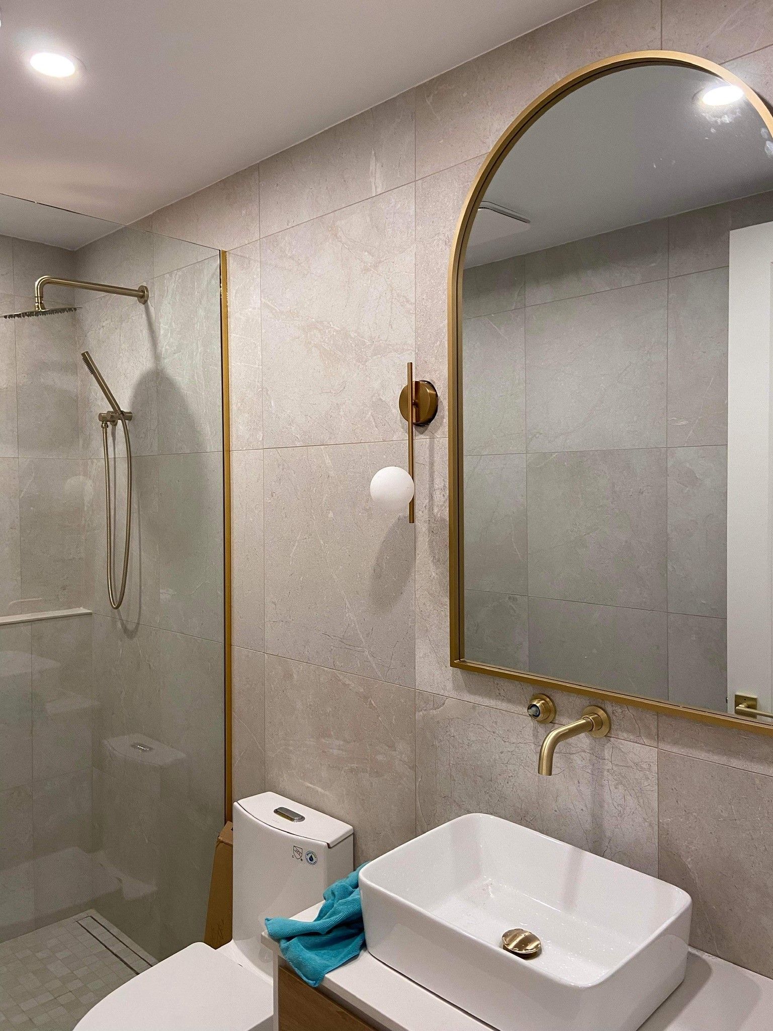 Une salle de bain avec WC , lavabo , douche et miroir.